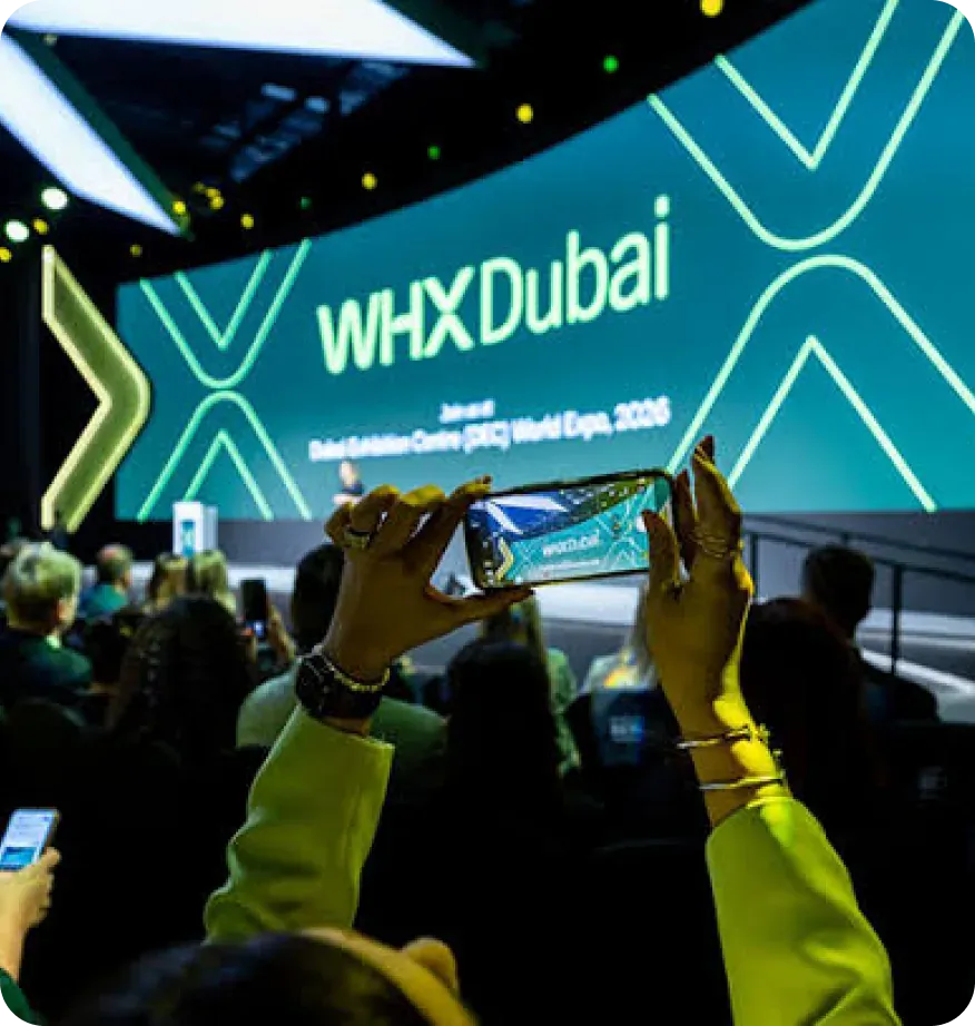 An attendee filming the main stage at WHX Dubai on their phone
